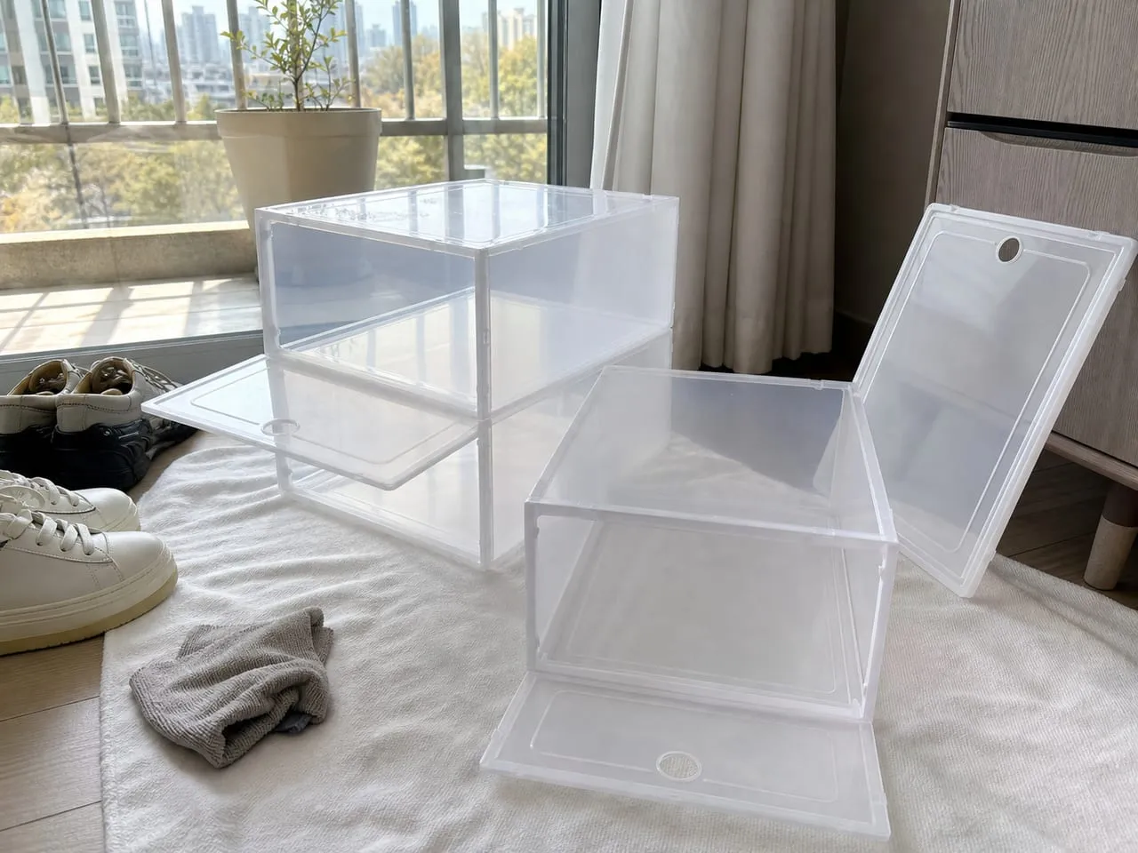 Newly assembled plastic shoe boxes airing out near a window