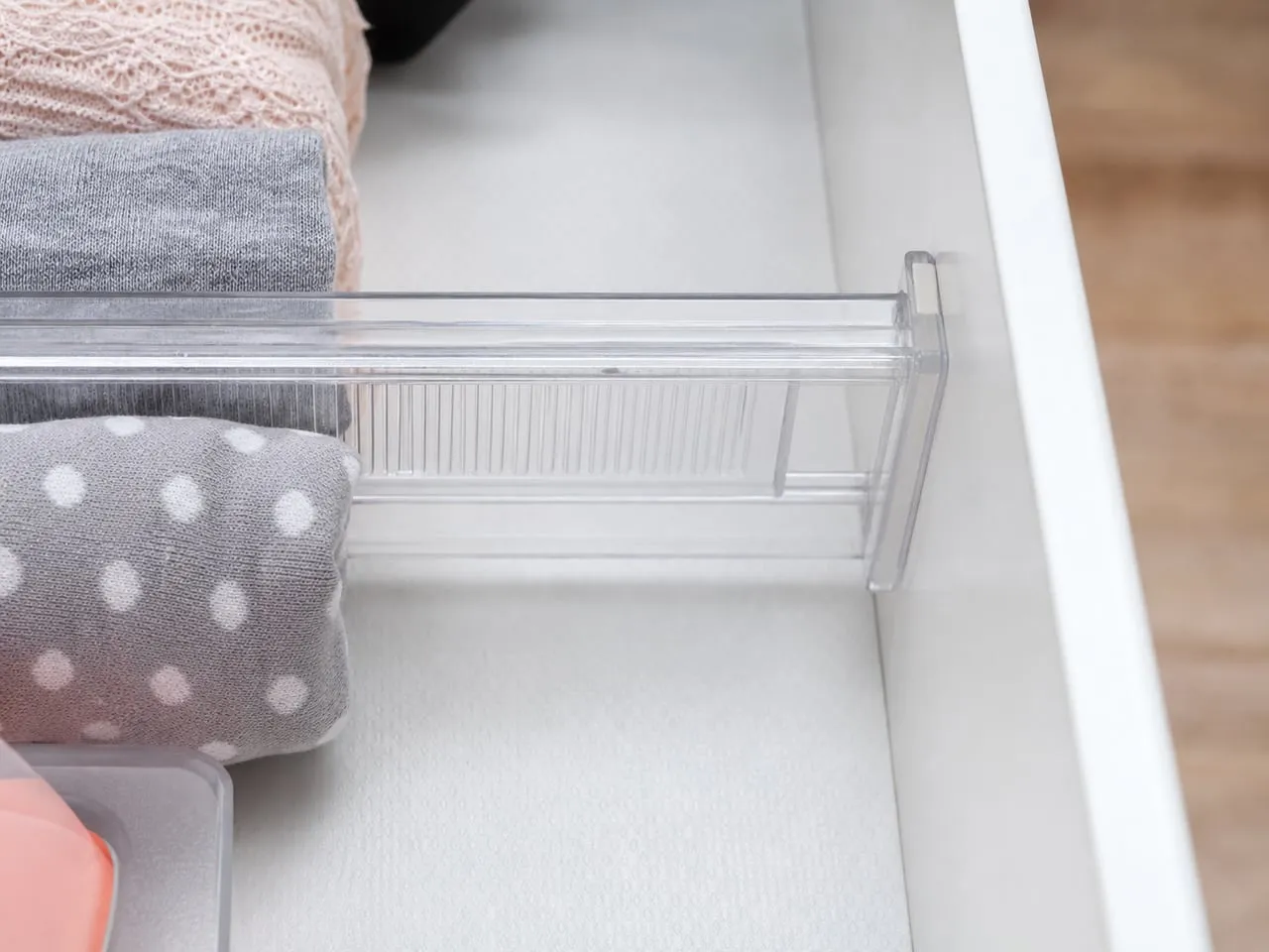 Small anti-slip pads placed at the end of a clear divider inside a smooth drawer