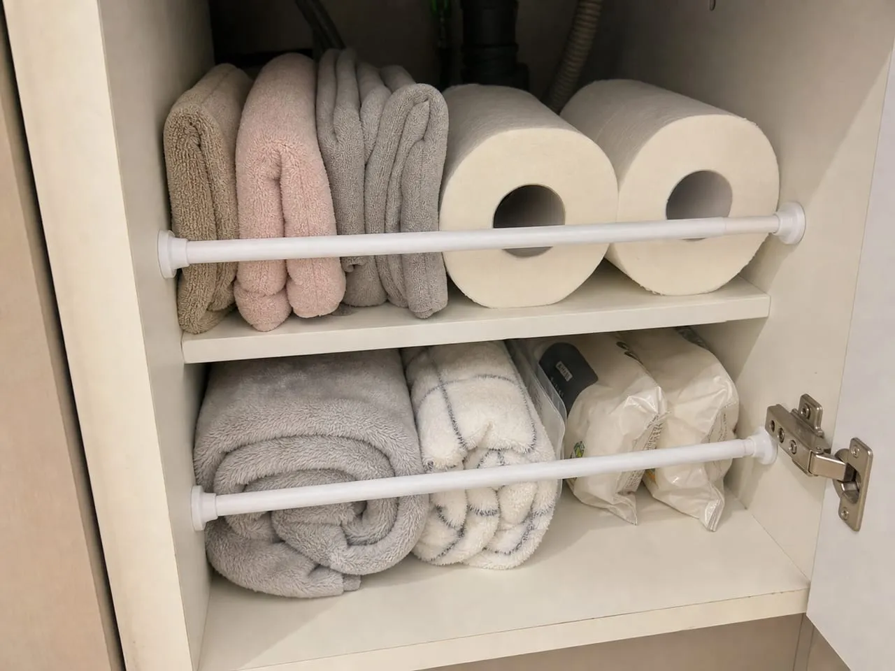 Small tension rods used as light dividers inside a cabinet