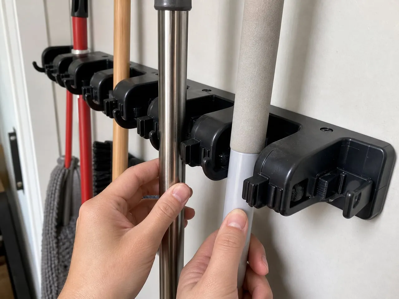 Testing slim and thicker handles against the roller grip of a black mop holder