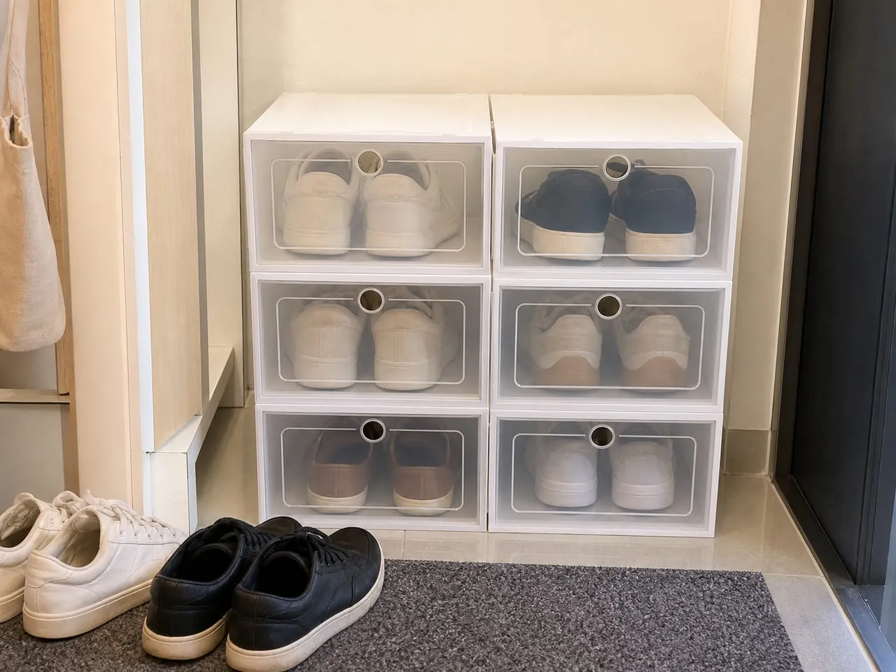 Transparent-front stackable shoe boxes arranged near an apartment entryway