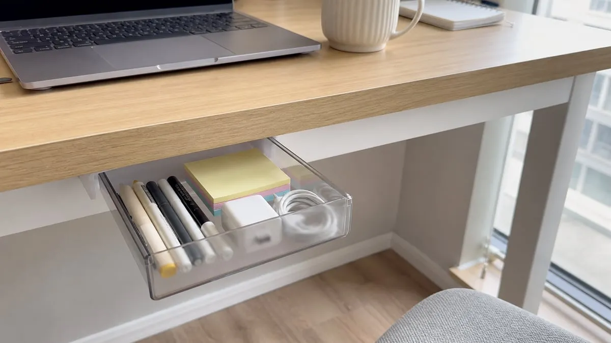 A translucent hidden drawer mounted under the left side of a desk