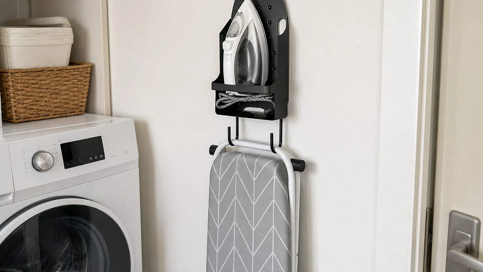 A black iron holder mounted on a laundry room wall with a folded ironing board hanging below