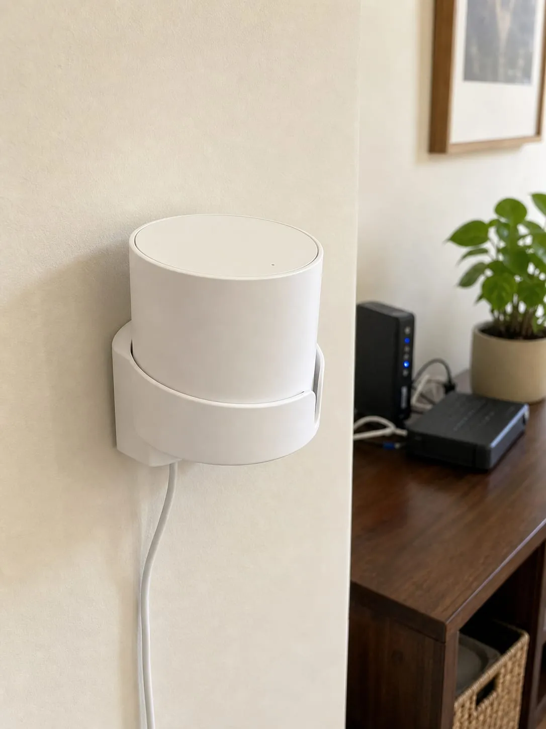 A white puck-shaped mesh router in a fitted wall bracket