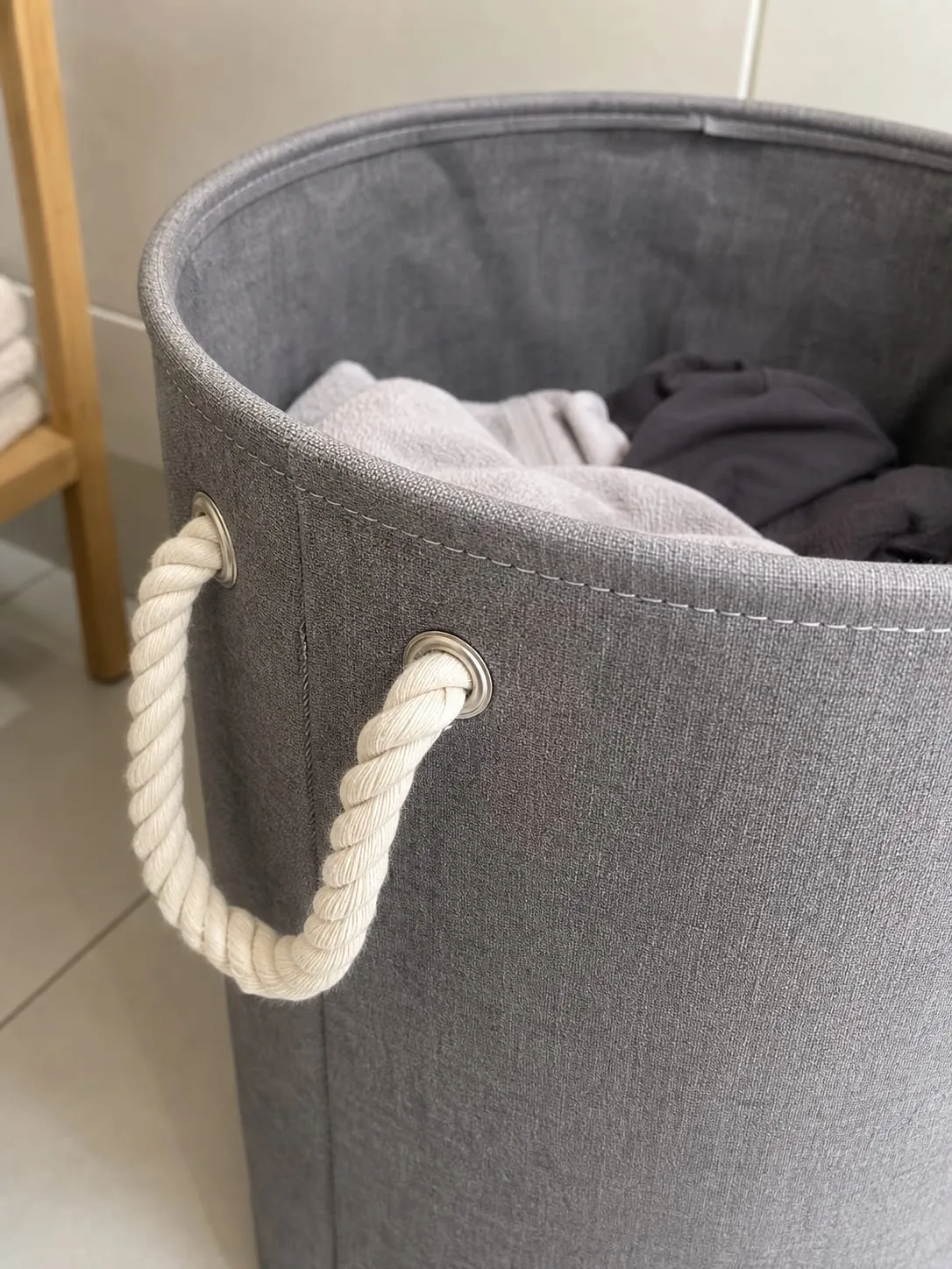 Close-up of the stitched rim and rope handle on a fabric laundry hamper