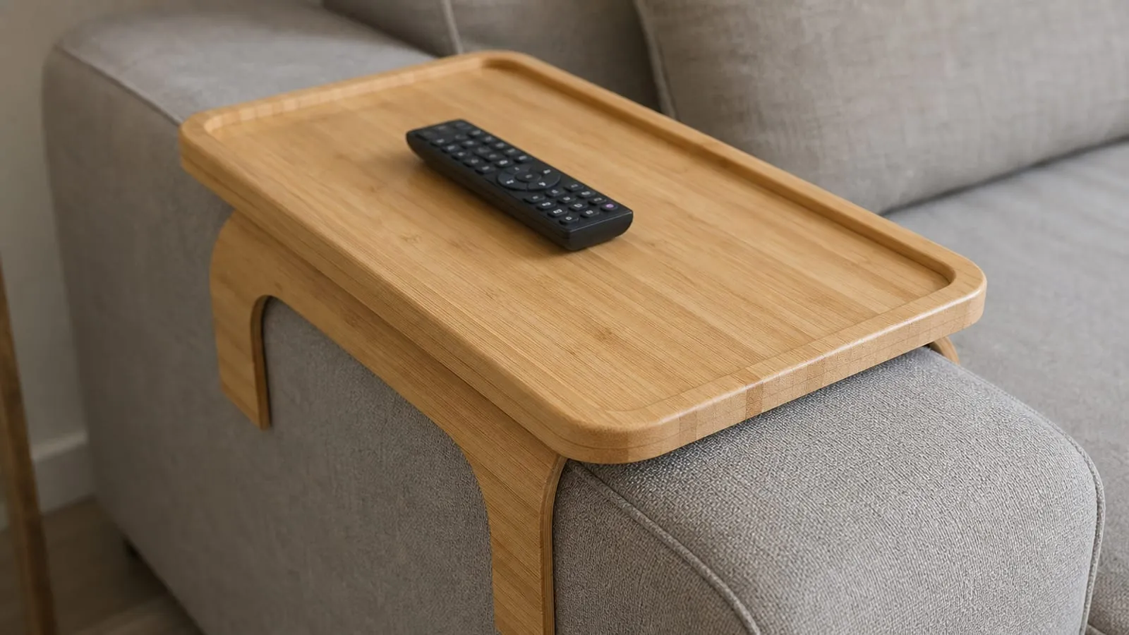 Close-up of curved wooden sofa-arm tray supports wrapping around a wide fabric armrest